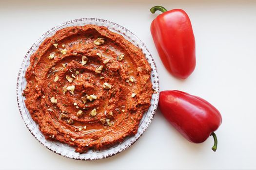 Muhammara, healthy walnut and roasted red bell pepper dip in a ceramic plate