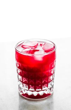 Alcohol drink, refreshment and cold beverage concept - Glass of red cocktail with ice, luxury bar party