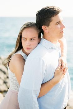 Woman hugging a man from behind looking into the distance. High quality photo