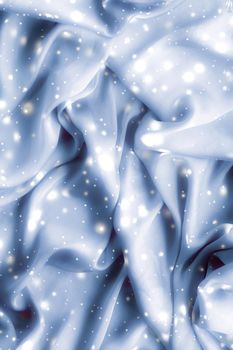 Winter fashion, shiny fabric and glamour style concept - Magic holiday blue soft silk flatlay background texture with glowing snow, luxury beauty abstract backdrop