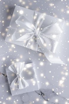 New Years Eve celebration, winter decoration and Valentines Day presents concept - Luxury holiday gifts with white silk bow and ribbons on marble background, Christmas time surprise