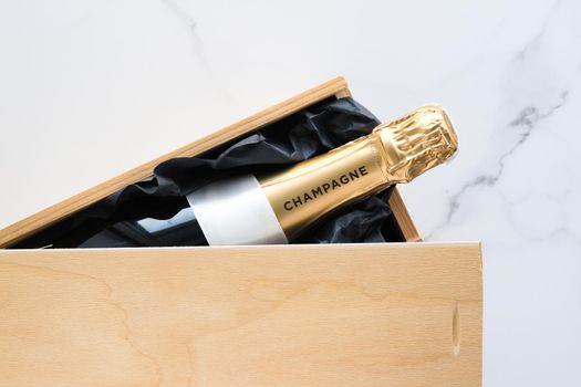 Wedding celebration, lifestyle and luxury present concept - A champagne bottle and a gift box on marble