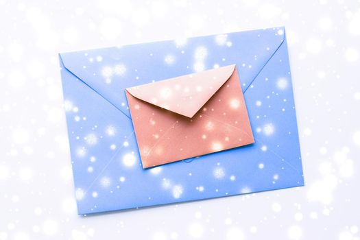 Greetings, postal service and online newsletter concept - Winter holiday blank paper envelopes on marble with shiny snow flatlay background, love letter or Christmas mail card design