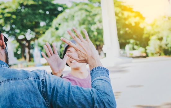 Close up of smiling people shaking hands in a park. Concept of two friends greeting each other with a handshake on the street, Back view of two smiling friends shaking hands on the street