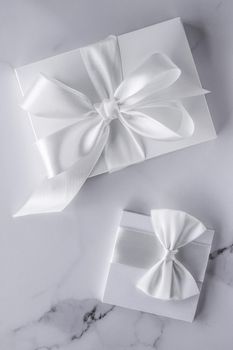 Romantic celebration, bridal decor and holiday present concept - Luxury wedding gifts with silk bow and ribbons on marble background