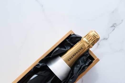 Wedding celebration, lifestyle and luxury present concept - A champagne bottle and a gift box on marble