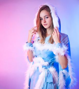 woman in a blue snow maiden costume poses on a light neon background