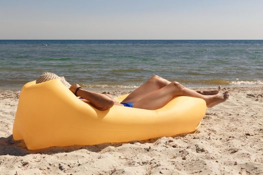 Girl relaxing on lamzac on the beach. Summer holiday idyllic on a tropical island.