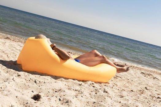 Girl relaxing on lamzac on the beach. Summer holiday idyllic on a tropical island.