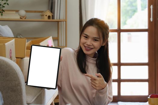 Asian SME business woman showing tablet empty screen at home office. Marketing time banner template.