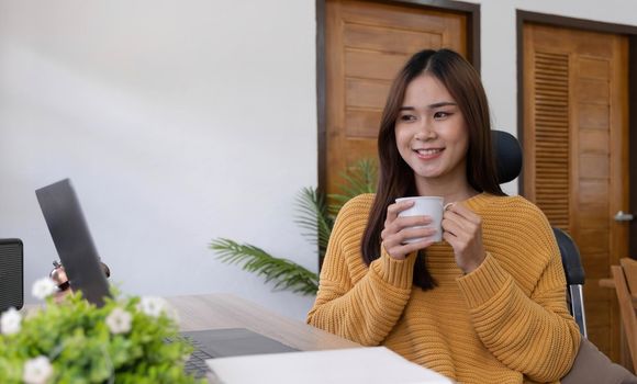 Profile side photo of smart chinese girl ceo expert sit desk work remote laptop texting typing report hold beverage mug in house indoors.