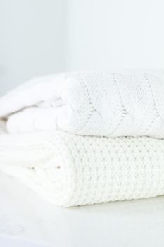 Knitwear, fabric textures and handmade items concept - Warm knitted clothes, soft and white