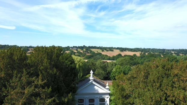 Aerial top down view from the drone onto the narrow passageway leading to a small chapel. Chapel located in a big green open area of fields near Rosary Manor, Mill Hill, North West London, London, UK.