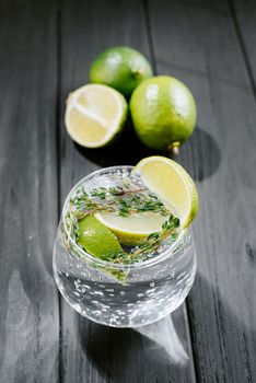 Lime lemonade with thyme, ginger and ice. wooden dark background