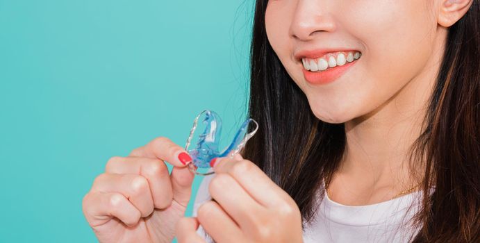 Teeth retaining tools after removable braces, Portrait young Asian beautiful woman smiling holding silicone orthodontic retainers for teeth, Orthodontics dental healthy care concept