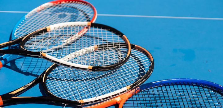 broken tennis rackets on clay tennis court.