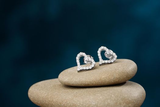 Silver heart shaped earrings with diamonds on river stones