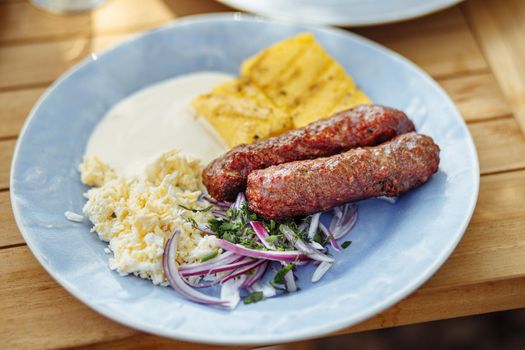 Traditional Romanian dish in a blue plate on a wooden table. selective focus