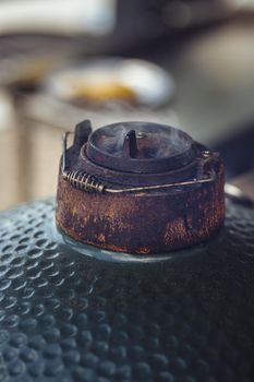 Close up image of the smoke over the valve of The Green Egg outdoor barbecue. Very popular ceramic bbq.