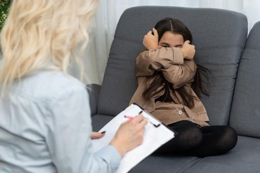 Female psychologist working with little girl at home.