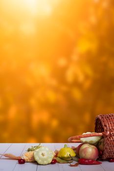 Autumn composition with a basket of apples, squash, peppers on the background of an autumn bokeh. Autumn harvest concept.