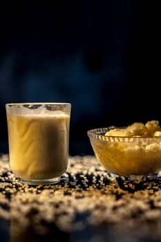 Indian style stamina and strength enrichment drink consisting of some raw eggs, milk and clarified butter or ghee in a glass along with some raw ghee and milk.Vertical shot with some sugar spread.