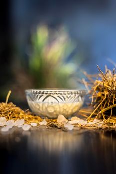 Close up of ayurvedic memory booster herb shankhpushpi on wooden surface along with some milk and sugar making a memory tonic together.