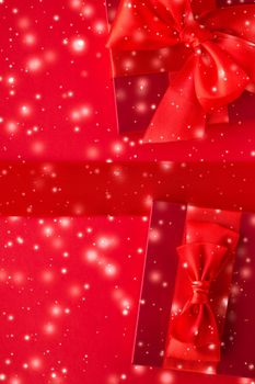 New Years Eve celebration, wrapped luxury boxes and Valentines Day card concept - Winter holiday gifts and glowing snow on red background, Christmas presents surprise