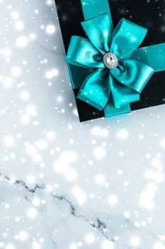 New Years Eve celebration, wrapped luxury boxes and cold season concept - Winter holiday gifts with emerald silk bow and glowing snow on frozen marble background, Christmas presents surprise