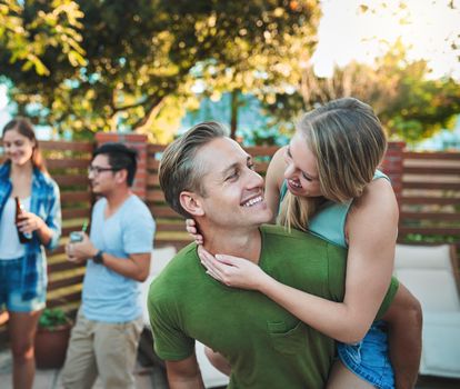 Love and friendship in perfect coexistence. a young couple enjoying a piggyback ride while hanging out with their friends