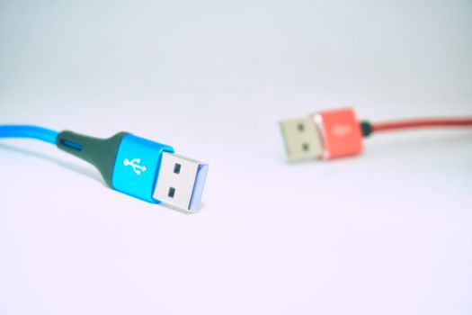 bring together or into contact so that a real or notional link is established. Blue red Universal Serial Bus cables isolated on a gray background. High quality photo