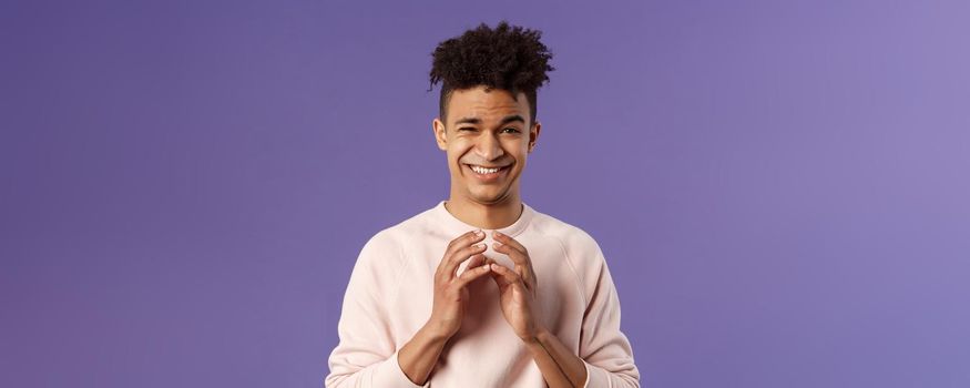 Portrait of creative young smart man with dreads, steeple fingers near chest and smirk devious, have perfect plan, scheming something for april fools day, standing purple background sly.