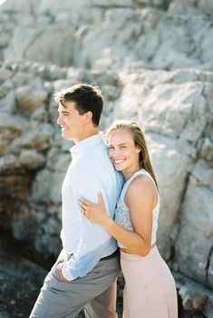 Smiling woman leaning against man from behind. High quality photo