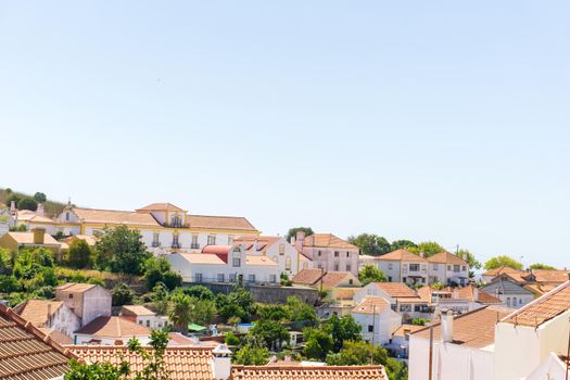 View of white houses with red tiled roofs in a Portuguese town on a sunny day