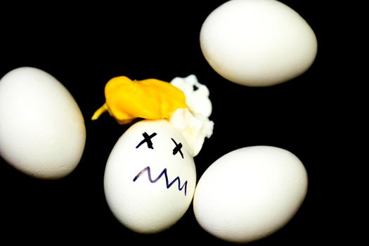 White eggs, one of them boiled and broken an simulating an accident