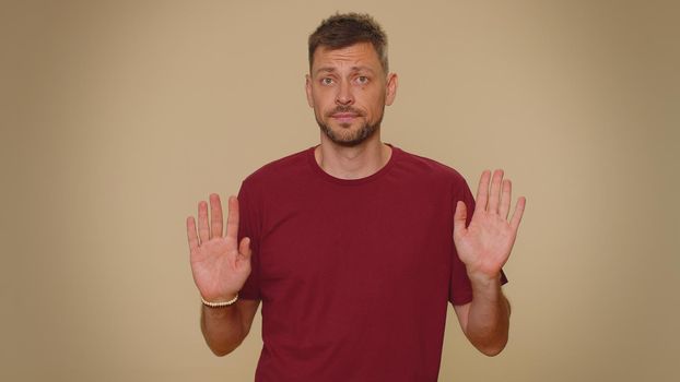 I am not guilty. Puzzled guilty young man pointing fingers hisself ask say who me no thanks i do not need it, refusal. Adult stylish male guy isolated alone on beige studio wall background indoors