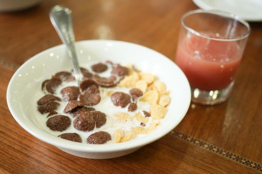 chocolate corn flakes in a bowl on table ,