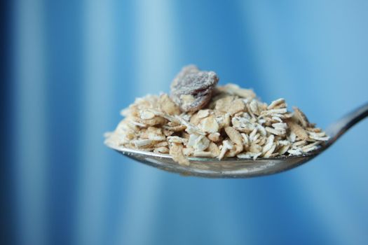 side view of oats flakes on a spoon ,