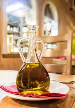 Natural food, Mediterranean diet and healthy eating concept - Bottles of organic extra virgin olive oil in Italian restaurant