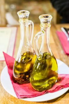 Natural food, Mediterranean diet and healthy eating concept - Bottles of organic extra virgin olive oil in Italian restaurant