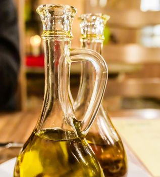 Natural food, Mediterranean diet and healthy eating concept - Bottles of organic extra virgin olive oil in Italian restaurant