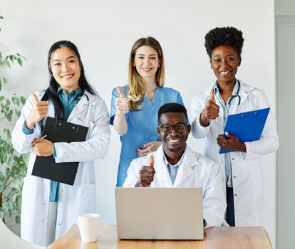 portrait of a doctors and nurses with laptop sitting by desk on their office