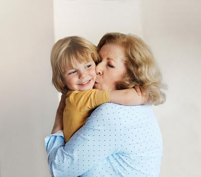 Portrait of grandmother and grandsonor having fun hugging and bonding together at home