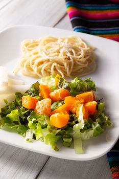 Fresh mixed lettuce and tangerine salad, accompanied by jicama "Pachyrhizus erosus" also known as Mexican yam bean or Mexican turnip. Closeup image.