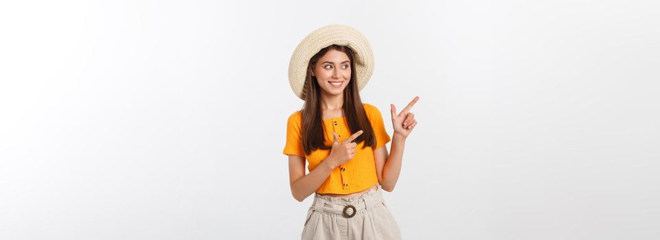 Teenager girl on summer vacation surprised and pointing finger on copy space over isolated white background