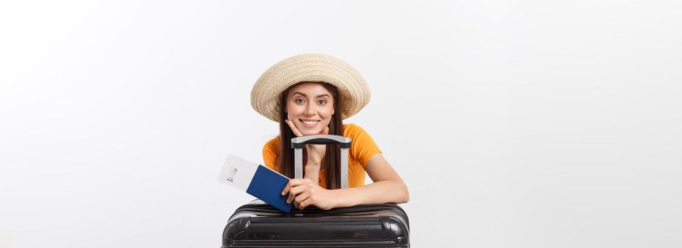 Travel concept. Studio portrait of pretty young woman holding passport and luggage. Isolated on white.