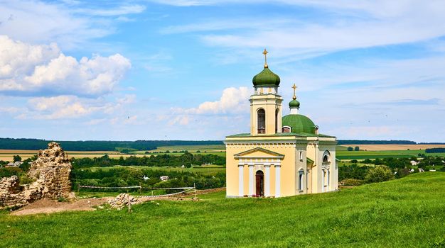 a building used for public Christian worship. Wonderful church and archeological site in a green field on a warm sunny day.