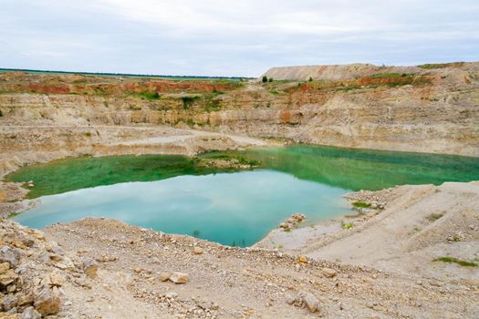 Lake formation in an old abandoned quarry. Quarry lake. Crushed stone dumps in a closed area for stone extraction. Termination of mining operations.