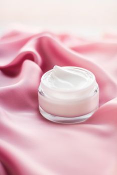 Beauty, anti-age cosmetics and skincare concept - Luxury face cream jar on a soft pink silk