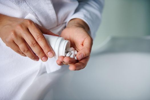 Details: pills in the hands of a female patient taking medicine. Dietary Supplements. Antidepressant and anxiolytic treatment. Compliance to physician's prescription. Healthcare. Close-up. Copy space